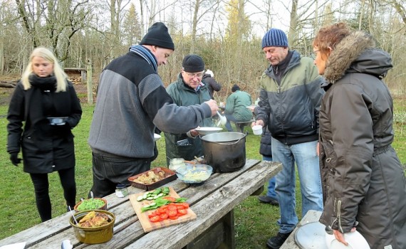 Deltagerne ved naturmadsarrangementet får skænket suppe.